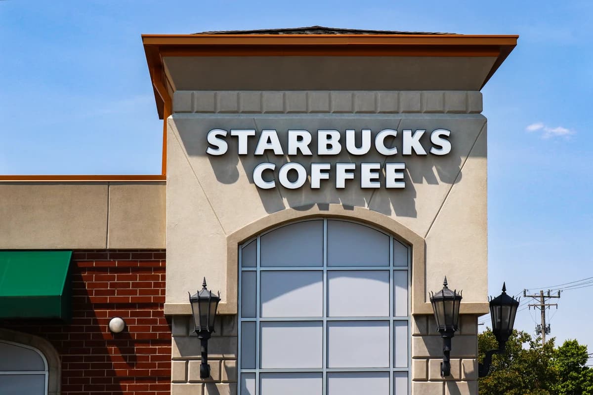 Фасад ресторана Starbucks Coffee с крупной вывеской.