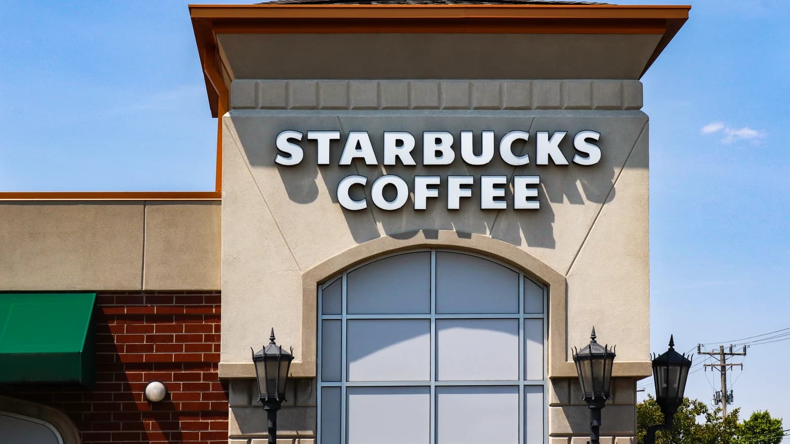 Фасад ресторана Starbucks Coffee с крупной вывеской.