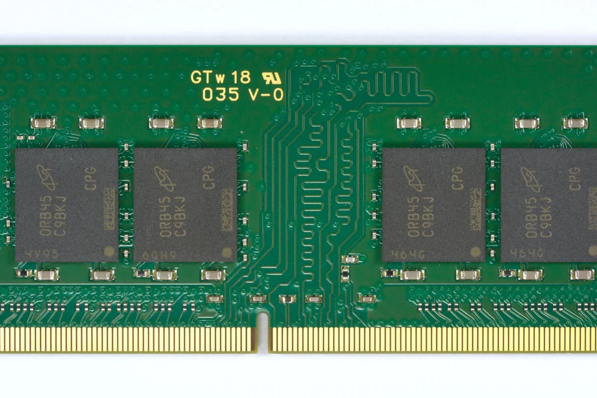 Зелёный модуль оперативной памяти DDR4 с четырьмя открытыми чипами на белом фоне.