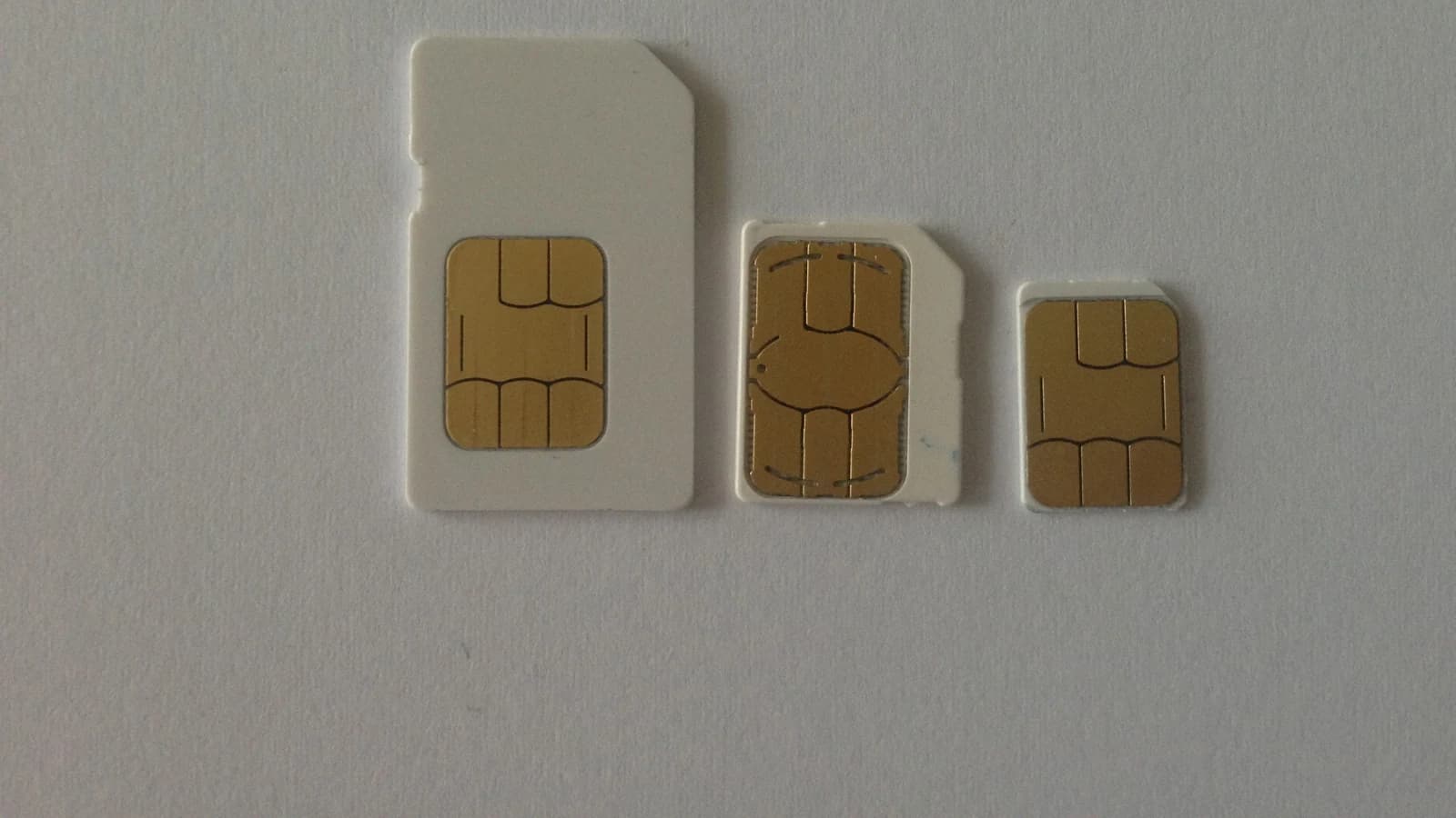Три SIM-карты разных размеров на светлом фоне