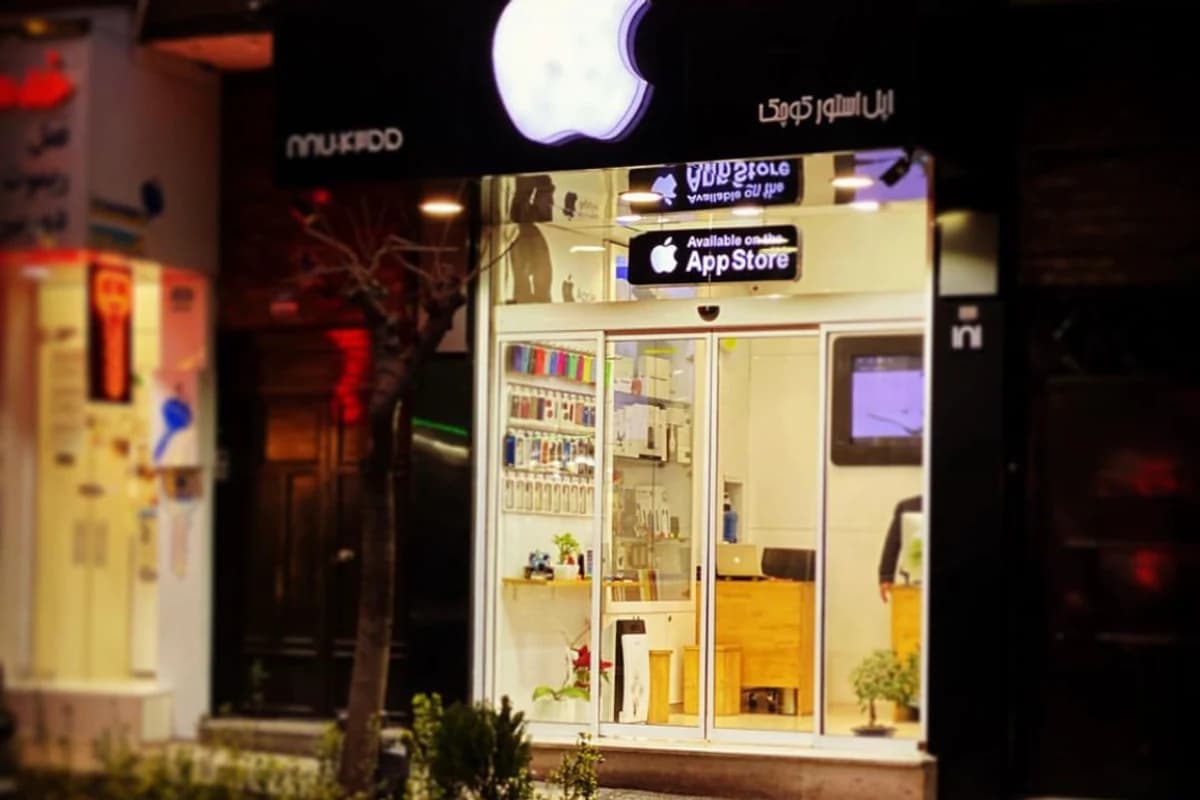 Освещённая витрина магазина с крупным логотипом Apple и вывеской App Store