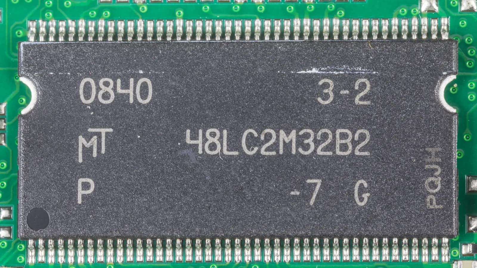 Крупный план микросхемы памяти Micron на зелёной печатной плате