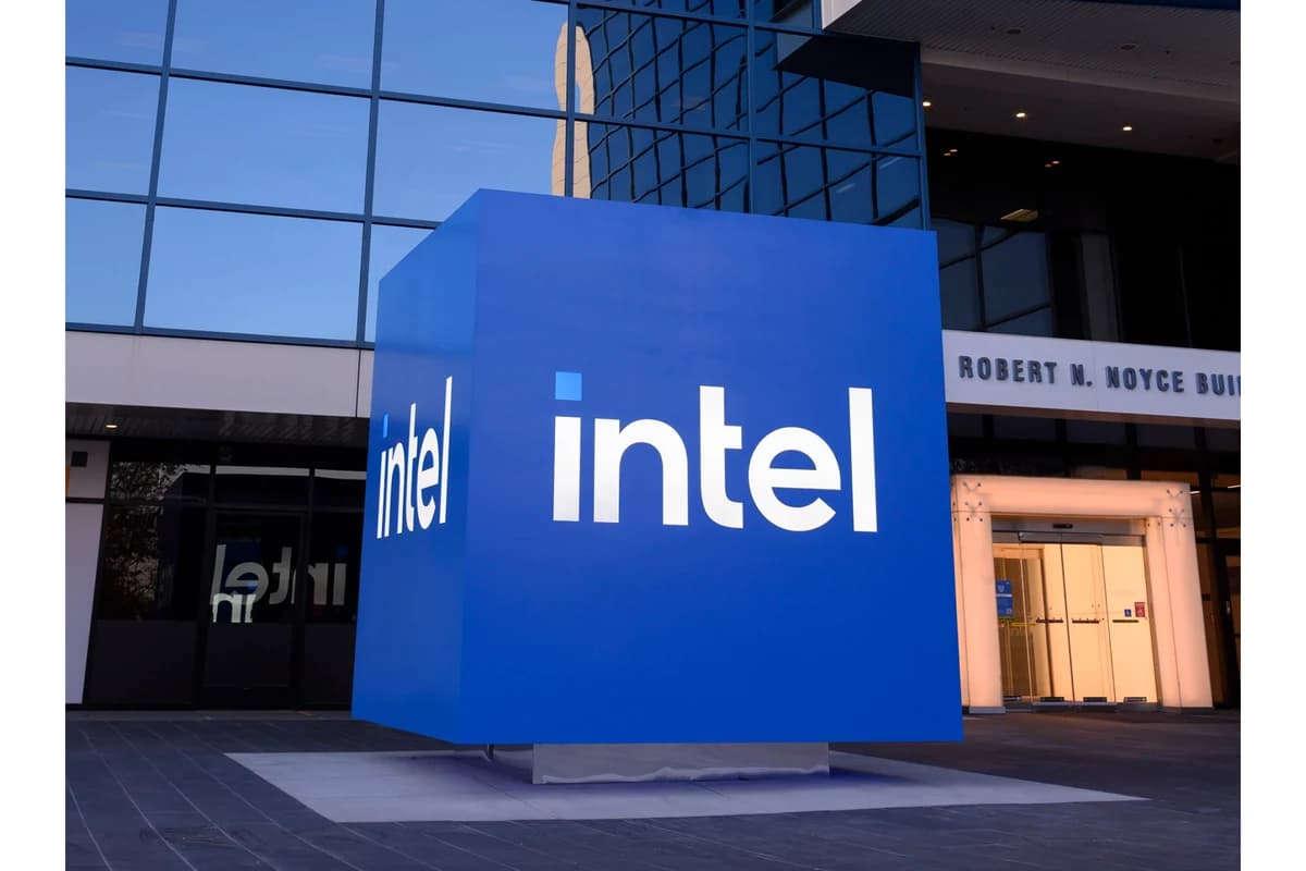 Синий куб с логотипами Intel перед входом в остеклённое офисное здание