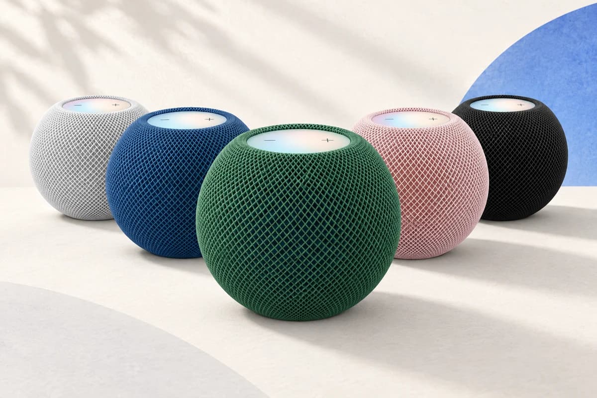 Пять сетчатых колонок HomePod mini 2, зелёная впереди, белая, синяя, розовая и тёмная позади; на плоских верхних панелях видны кнопки громкости.