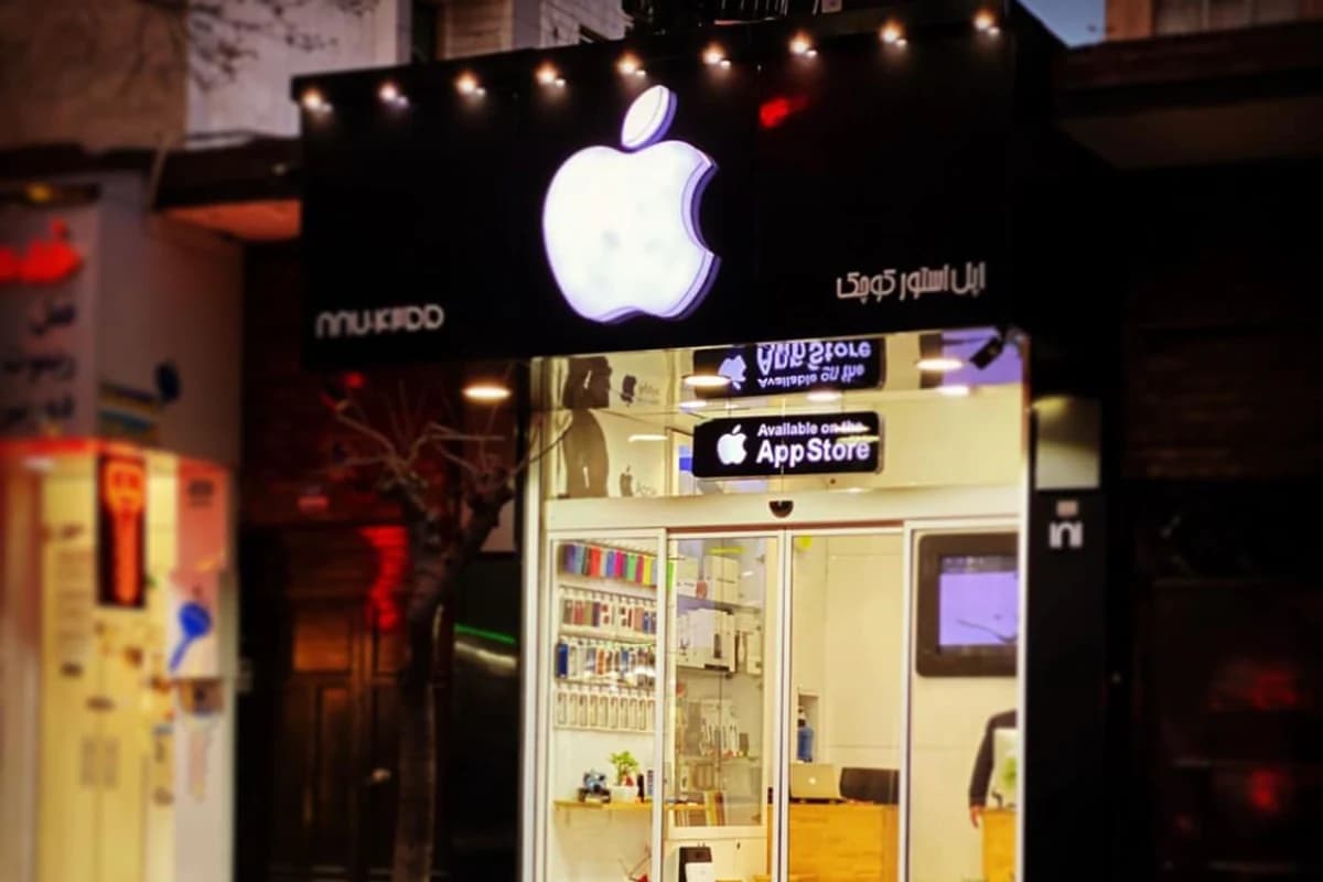 Освещённая витрина магазина с крупным логотипом Apple