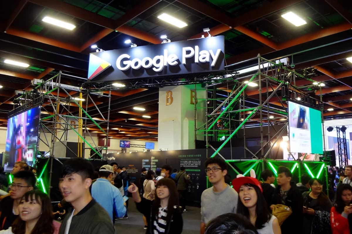 Вывеска Google Play над выставочным стендом с посетителями