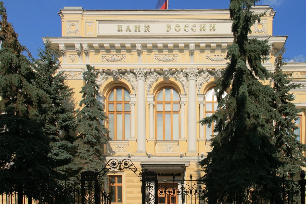 Фасад здания Банка России за кованой оградой, на крыше установлен российский флаг