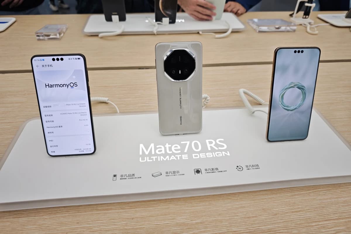 Смартфоны Huawei на витрине, на экране одного открыта информация о HarmonyOS