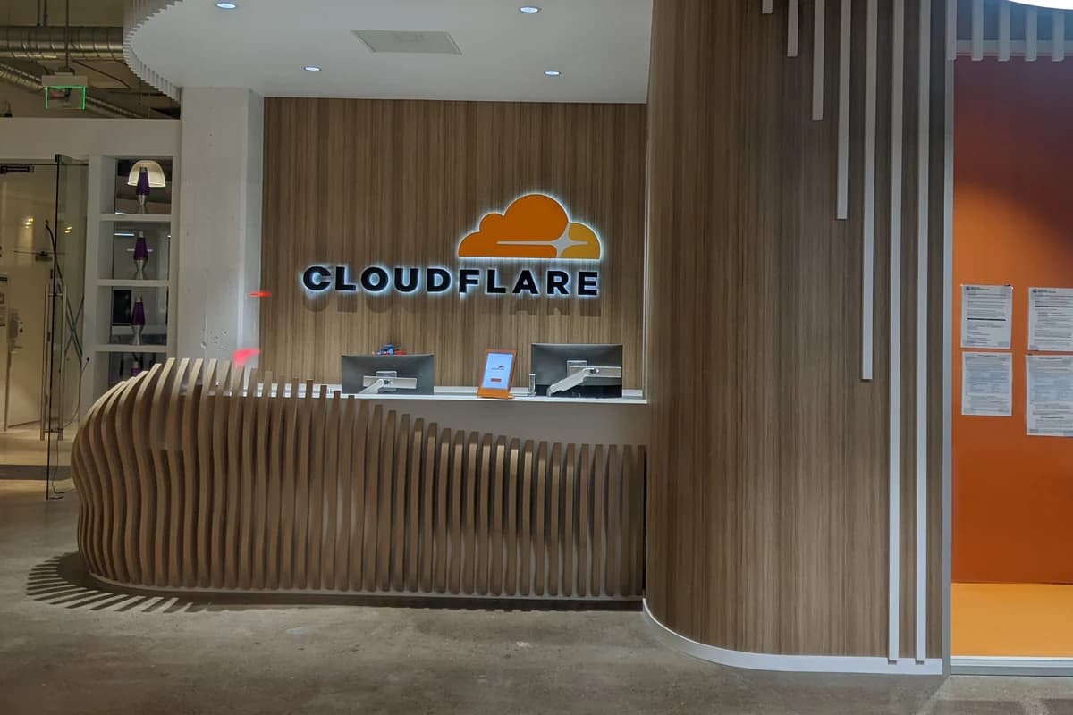 Стойка ресепшена в офисе с подсвеченной вывеской Cloudflare