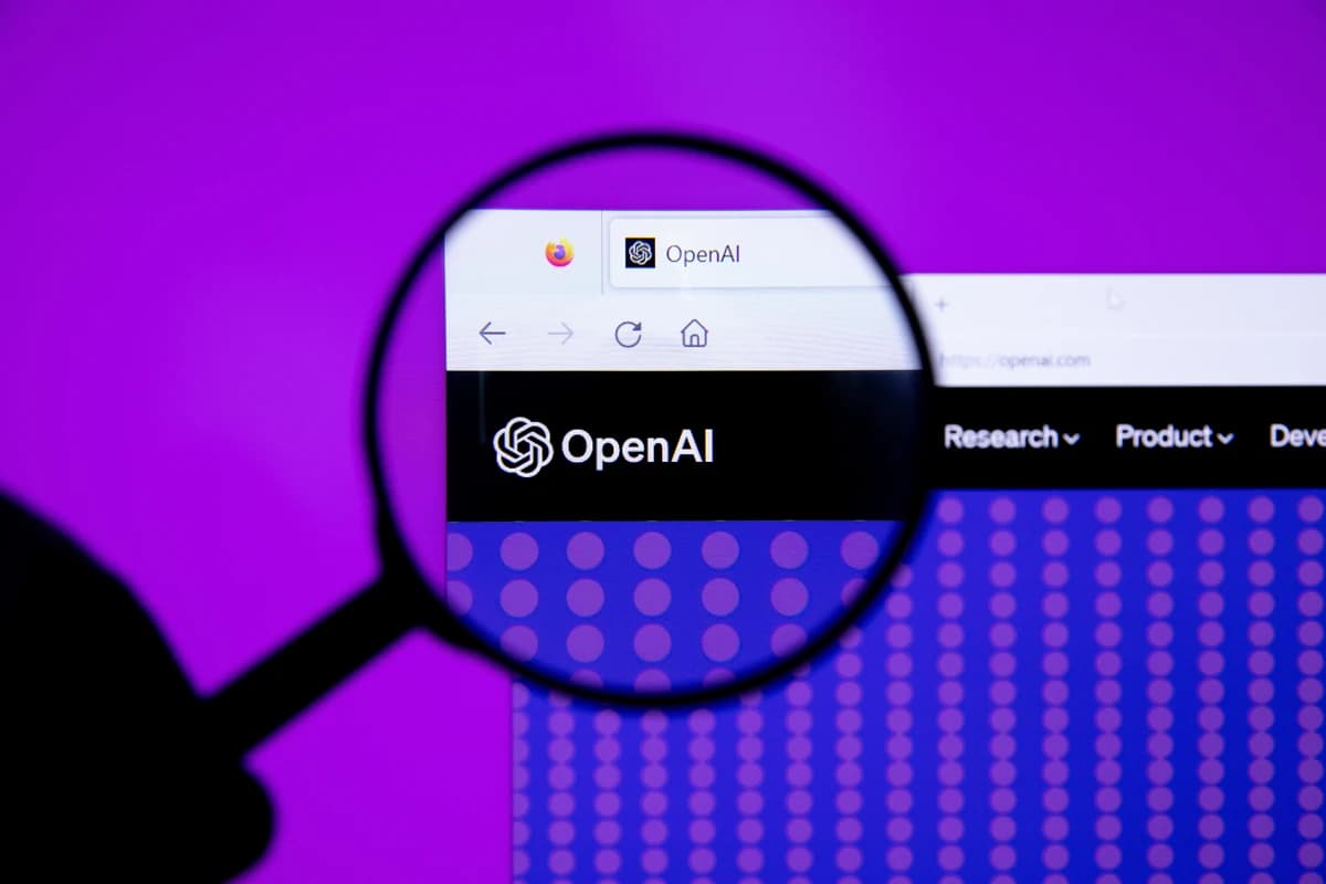 Логотип OpenAI на экране компьютера под увеличительным стеклом