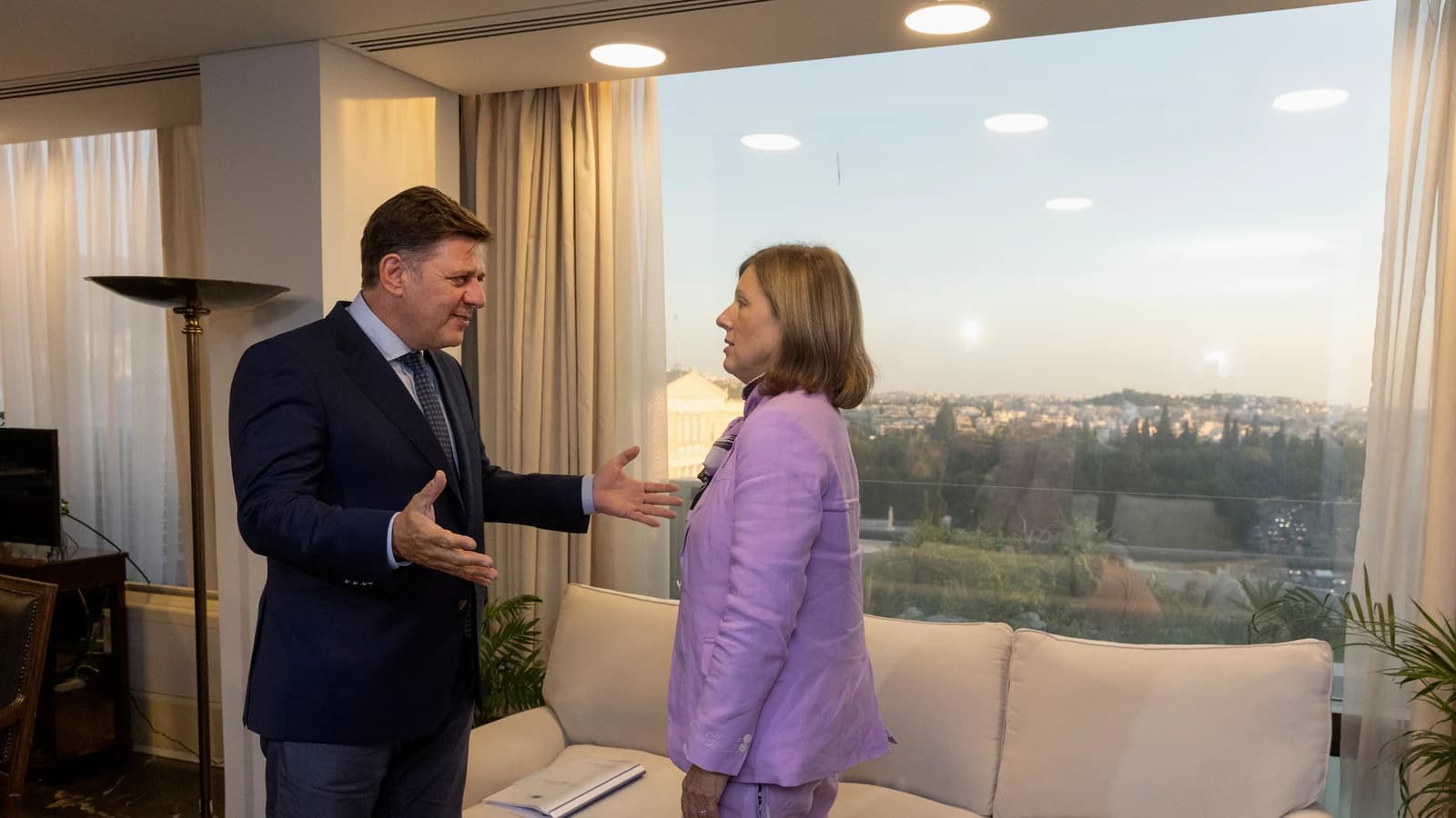 Денис Мантуров беседует с женщиной в светлой гостиной
