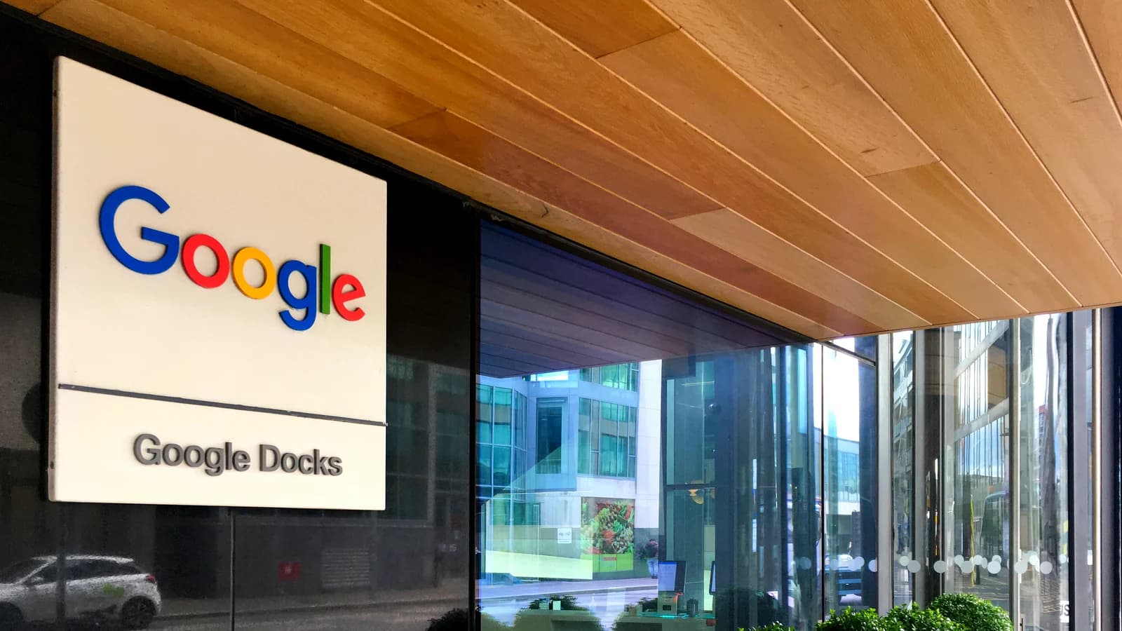 Вывеска Google у стеклянного входа в здание
